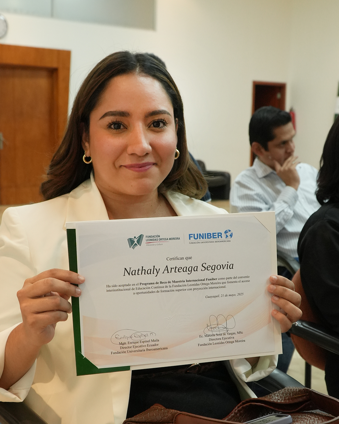 Becaria mostrando su certificado de maestría